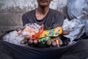 “El mono de Ciénaga” – “Callejón de los chirretes” Valledupar – El mono entre la basura revelando los alimentos de diario consumo: Pan, Frutiño y cigarro – 14/02/2025